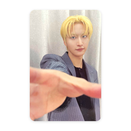 ATEEZ Seonghwa GOLDEN HOUR Part.5 pop-up reward photocard — yellow-blond hair, navy pinstripe blazer over a black tee, arm fully extended toward the camera with fingers spread, gray curtain background.