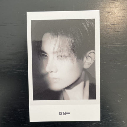 ENHYPEN Heeseung THE SIN VANISH Music Korea POB Polaroid — black and white side profile hair swept over face dramatic diagonal shadow