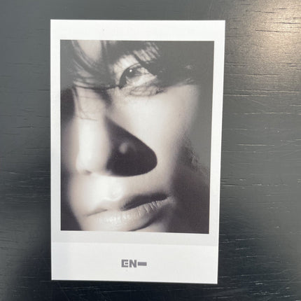 ENHYPEN Jake THE SIN VANISH Music Korea POB Polaroid — black and white extreme close-up upper face one eye lit hair falling forward half face in shadow
