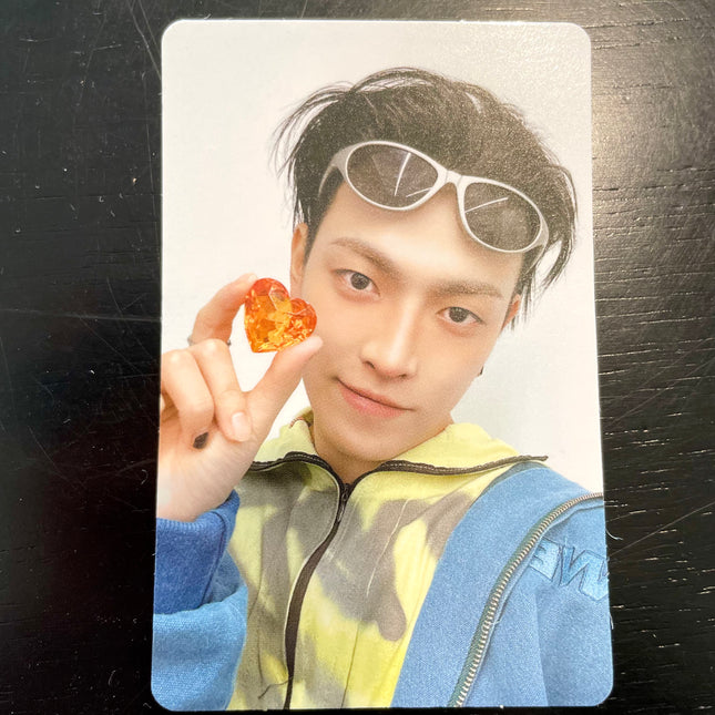 ATEEZ Hongjoong ANITEEZ IN COLOR Type B POB photocard — black hair with white wraparound sunglasses on his head, yellow tie-dye top and blue jacket, holding an orange jewel heart up to the camera
