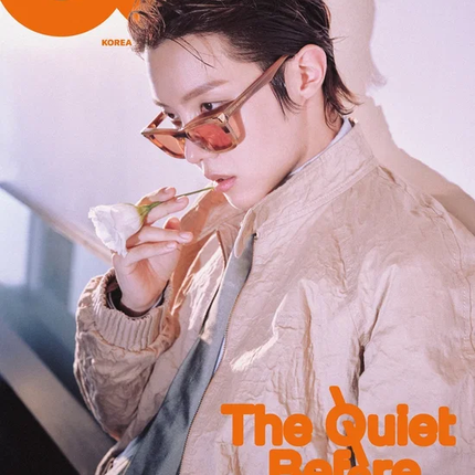 BTS j-hope GQ Korea September 2026 Cover C — close-up portrait in amber-tinted sunglasses and a beige utility jacket, warm orange backdrop, candid hand-near-chin pose, 'The Quiet Before' wordmark in orange.